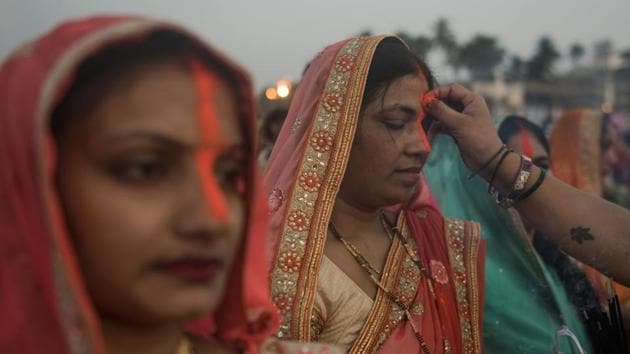 Women devotees put vermillion during Chhath Puja rituals at Juhu Beach in Mumbai. (Satish Bate/HT Photo)