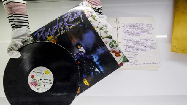 An assistant displays American singer-songwriter Prince’s original ‘Purple Rain’ record and his handwritten prescript of Purple Rain during a press preview of the exhibition at the O2 Arena in London. A large area has been dedicated to the album ‘Purple Rain’ and the film of the same name, notably featuring the purple trench coat Prince wore throughout the movie. (Tolga Akmen / AFP)