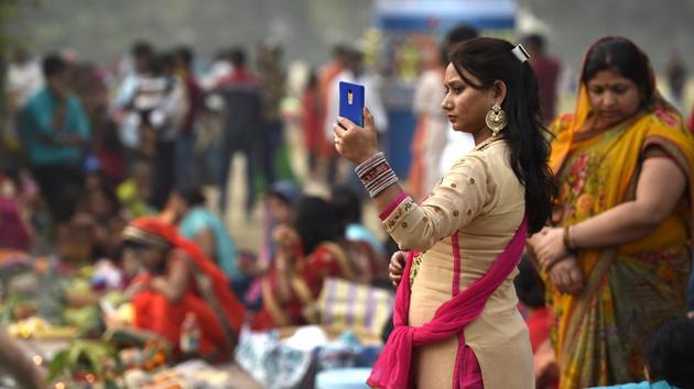 A woman takes a selfie during the Chhath Puja festival near India Gate in New Delhi. Chhath, this year, commenced on 24th October and ended on the 27th morning with devotees offering Arghya’ to the rising sun. (Arvind Yadav/HT PHOTO)