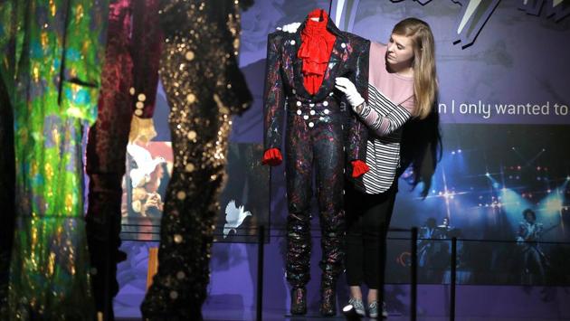 Curator Sarah Bitler adjusts a costume during the world premiere of the exhibition at the O2, London. The exhibition features the guitar used in his 1980 US national television debut and charts Prince’s rise to stardom with clothing worn on his ‘Purple Rain’ and ‘LoveSexy’ tours in the same decade. (Peter Nicholls / REUTERS)