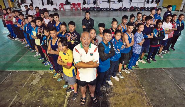 L Ibongcha Singh, who has coached Olympic boxer Mary Kom, among others, strikes a pose with his students at the Khuman Lampka stadium in Imphal. Seen at the back is Dingko, now a full-time coach here.(Anshuman Poyrekar / HT Photo)