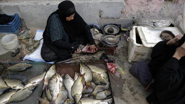 Women gut and sell fish at a market in central Chabaish, Iraq. In the largely agrarian society in Iraq’s vast wetlands, women comprise a sizeable proportion of the workforce, as they’re engaged in fishing, raising buffalo and selling them in local markets. However, farming and sewage run-off have depleted fishing stocks, forcing some fisherfolk to resort to using car batteries and chemicals. (Susannah George / AP)