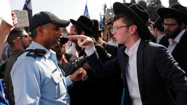 An ultra-Orthodox Jewish demonstrator points towards an Israeli policeman during a protest against Israeli army conscription outside the Israeli parliament in Jerusalem on October 23, 2017. (Thomas Coex / AFP)