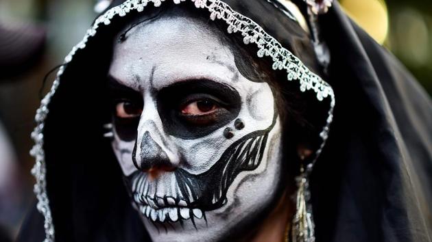 A woman disguised as ‘Catrina’ (Mexican representation of death) takes part in the ‘Catrinas Parade’ along Reforma Avenue, in Mexico City on October 22, 2017. (Ronaldo Schemidt / AFP)