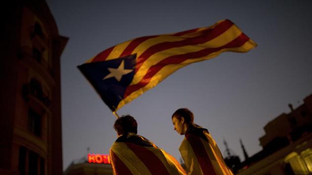 Pro-independence supporters carry an 'Estelada' or independence flag in downtown Barcelona.(AP Photo)