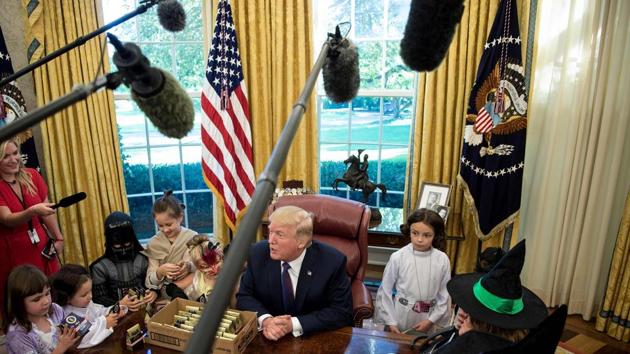 More than a dozen costumed kids, including little witches and Princess Leias, a pint-sized Darth Vader, and a purple-haired unicorn gathered around the Resolute Desk, where the president handed out little boxes of White House Hershey’s Kisses. (AFP Photo)