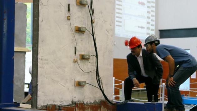 Prof Nemkumar Banthia and Salman Soleimani-Dashtaki examine a wall retrofitted with a coating of the quake-resistant material after a test.(Image courtesy: UBC Public Affairs) Prof Nemkumar Banthia and Salman Soleimani-Dashtaki examine a wall retrofitted with a coating of the quake-resistant material after a test.(Image courtesy: UBC Public Affairs)