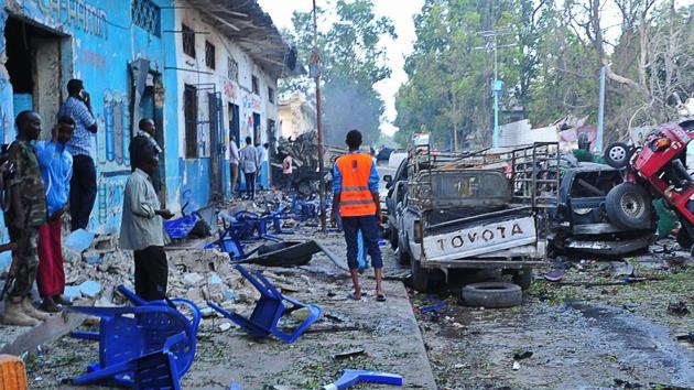 People stand among damages at the scene of a blast after two car bombs exploded in Mogadishu on October 28, 2017. A car packed with explosives blew up outside a hotel in Mogadishu on October 28 as a minibus also exploded at a nearby junction, with the emergency services reporting "many dead bodies". (AFP Photo) People stand among damages at the scene of a blast after two car bombs exploded in Mogadishu on October 28, 2017. A car packed with explosives blew up outside a hotel in Mogadishu on October 28 as a minibus also exploded at a nearby junction, with the emergency services reporting "many dead bodies". (AFP Photo)