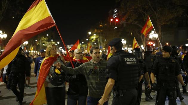 A Catalan policeman talks to an anti-independence supporter as demonstrators are prevented from moving forward during a march against the unilateral declaration of independence approved earlier by the Catalan parliament in downtown Barcelona Friday. (AP Photo) A Catalan policeman talks to an anti-independence supporter as demonstrators are prevented from moving forward during a march against the unilateral declaration of independence approved earlier by the Catalan parliament in downtown Barcelona Friday. (AP Photo)
