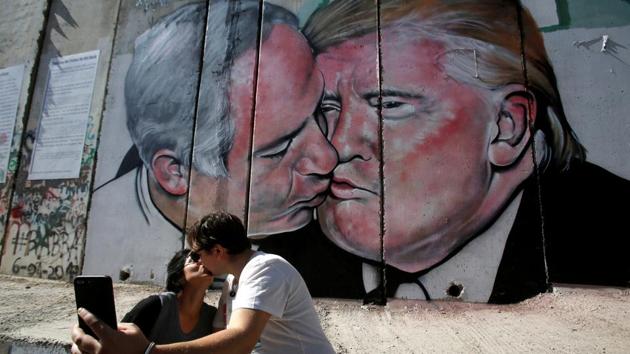 Tourists kiss each other as they stand in front of a mural depicting US President Donald Trump and Israel's Prime Minister Benjamin Netanyahu kissing each other in the West Bank city of Bethlehem October 29, 2017. (Reuters Photo) Tourists kiss each other as they stand in front of a mural depicting US President Donald Trump and Israel's Prime Minister Benjamin Netanyahu kissing each other in the West Bank city of Bethlehem October 29, 2017. (Reuters Photo)
