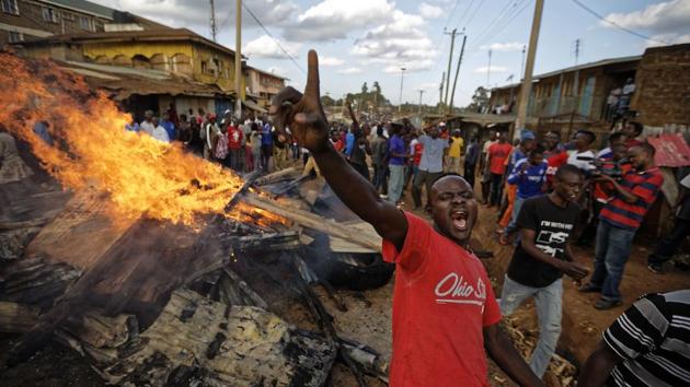 An opposition supporter yells in front of a burning barricade built from material looted from the property of a man of the Kikuyu tribe in the Nairobi’s Kawangware slum. While the dynamics of 2017’s political crisis are very different, the memory of the bloodshed a decade ago is never far away. (Ben Curtis / AP) 