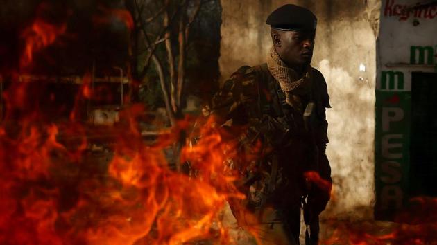 A police officer walks by a burning barricade during an opposition protest in the slum area of Mathare in Nairobi, Kenya, on October 26, 2017. Kenyans trickled into polling stations even as supporters of opposition leader Raila Odinga, who called for an election boycott, managed to prevent hundreds of polling stations from opening, prompting violent clashes with police which continued for several days, leaving nine dead and scores injured. (Siegfried Modola / REUTERS) 