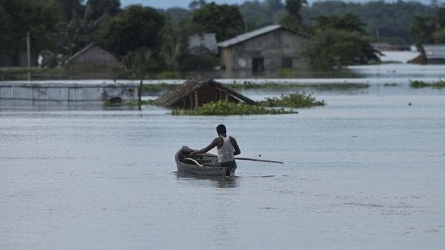 A man rowing a boat on a swollen Brahmaputra in Assam. The river, which originates in Tibet, is called Yarlung Tsangpo River in China.(AP File Photo)