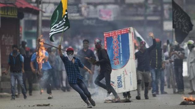 A Kashmiri protester holds a flag of Pakistan during a protest in Srinagar.(AP File Photo)