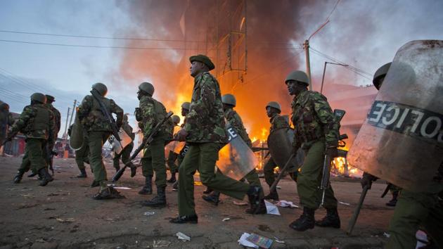 Police move past burning shops during clashes in Nairobi, Kenya on October 27, 2017. At least 49 people have died since the first presidential election of August 8, which was later overturned, prompting Kenya’s worst political crisis in a decade. The current flare is the worst since a 2007 vote sparked months of politically-driven ethnic violence that left 1,100 people dead. (Darko Bandic / AP) 