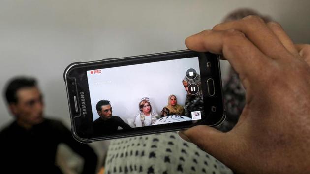 Seated on plastic chairs, the young bride and groom looked slightly nervous. Around the couple, guests took photos with mobile phones. Almost everything in the scene would have been impossible during the three years of brutal IS rule. (Delil souleiman / AFP) 