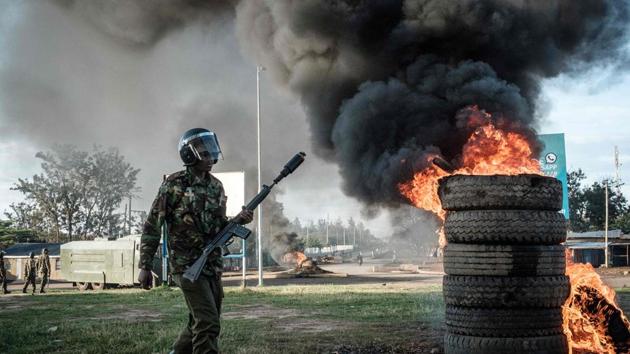 An anti-riot police officer walks by burning tires set alight by from supporters of Raila Odinga’s National Super Alliance (NASA) at Kondele where a polling station was supposed to be setup for the repeat presidential election on October 26, 2017. Kenyans voted in an election that has polarised the nation and sparked concern about the future of east Africa’s most stable democracy. Following Odinga’s boycott, Kenyatta is guaranteed a crushing win. (Yasuyoshi Chiba / AFP) 