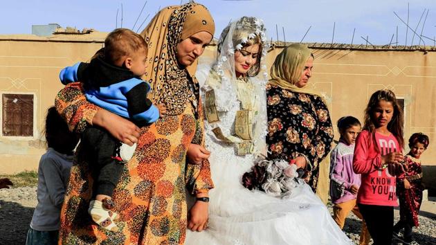 Syrian women escorted bride Heba as they participated in celebrations during her wedding. Heba entered the venue in a delicate veil edged with white flowers rested on her tightly curled hair, and a gold headpiece dangled over her eyebrows. Her hands were painted with henna as she fiddled nervously with a bouquet of artificial flowers. (Delil souleiman / AFP) 
