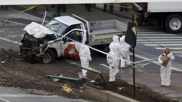 Authorities stand near the damaged pickup truck after the driver drove onto a bike path near the World Trade Center in New York City, killing at least eight people. (AP) Authorities stand near the damaged pickup truck after the driver drove onto a bike path near the World Trade Center in New York City, killing at least eight people. (AP)