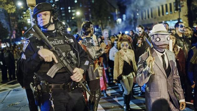 Heavily armed police guard as revelers march during the Greenwich Village Halloween Parade on October 31, 2017, in New York. The city’s always surreal Halloween parade marched on Tuesday evening under the shadow of fear, hours after the truck attack killed several people on a busy city bike path, albeit under tight security and a large police presence. (Andres Kudacki / AP) Heavily armed police guard as revelers march during the Greenwich Village Halloween Parade on October 31, 2017, in New York. The city’s always surreal Halloween parade marched on Tuesday evening under the shadow of fear, hours after the truck attack killed several people on a busy city bike path, albeit under tight security and a large police presence. (Andres Kudacki / AP)
