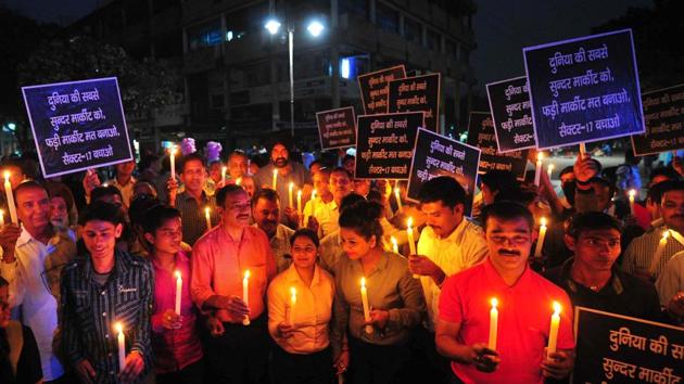 The joint action committee of Sector 17 traders holding a candle march during an hour-long blackout to protest against street vendors at the Plaza in Chandigarh.(Keshav Singh/HT)