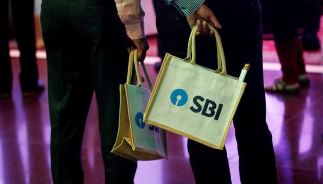The State Bank of India (SBI) logo is seen on bags carried by people in Mumbai.(REUTERS)
