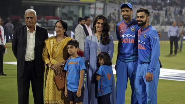 Virat Kohli poses along with Ashish Nehra’s family after the end of the game at The Kotla. (AP) 