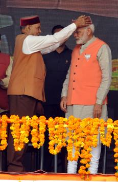 BJP’s chief ministerial candidate Prem Kumar Dhumal presenting a Himachali cap to Prime Minister Narendra Modi. (SHYAM SHARMA/HT)