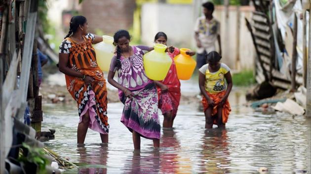 Women carrying drinking water wade through a flooded street in Velacherry after heavy rains in Chennai. The reservoirs catering to the water needs of Chennai are slowly filling up and with rains predicted, the water levels are expected to rise further. (R Senthil Kumar / PTI) Women carrying drinking water wade through a flooded street in Velacherry after heavy rains in Chennai. The reservoirs catering to the water needs of Chennai are slowly filling up and with rains predicted, the water levels are expected to rise further. (R Senthil Kumar / PTI)
