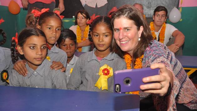 A NGO member takes selfie with students at the government primary school at Nanoorkheda.(Vinay S Kumar/HT Photo)