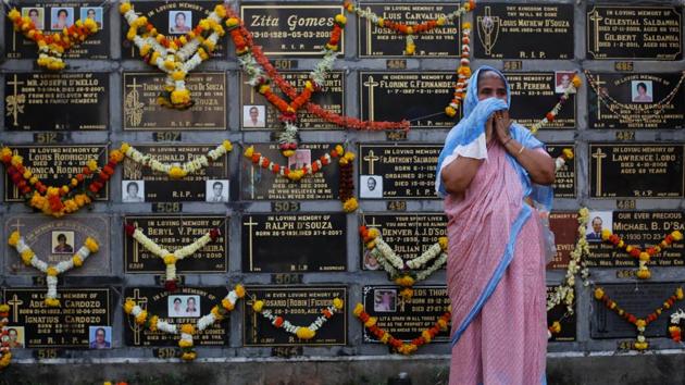A woman cries after praying beside a columbarium at a cemetery during the observance of All Souls Day in Mumbai on November 2, 2017. (Danish Siddiqui / REUTERS)