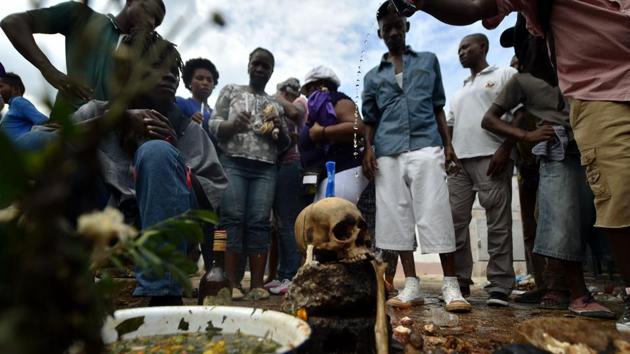 Voodoo devotees offer candles, alcohol and food to Baron Samdi, known for his fondness for tobacco and rum, his debauchery and obscenity during Fete Gede celebrations. The Day of the Dead is celebrated on the first two days of November during All Saints and All Souls Day. (Hector Retamal / AFP) Voodoo devotees offer candles, alcohol and food to Baron Samdi, known for his fondness for tobacco and rum, his debauchery and obscenity during Fete Gede celebrations. The Day of the Dead is celebrated on the first two days of November during All Saints and All Souls Day. (Hector Retamal / AFP)