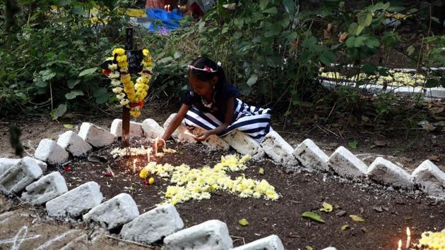A child pay respect to to the dear departed by offering flowers and placing candles at the St. Sepulchre cemetery on Thursday, as Christians in the city marked November 2 as All Souls Day. (RAHUL RAUT/HT PHOTO)