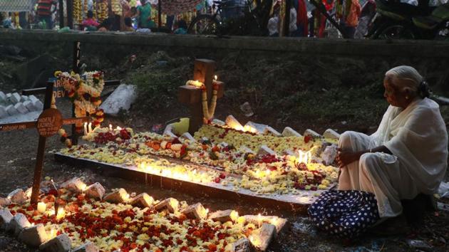 An old women pay respect to to the dear departed by offering flowers and placing candles at the St. Sepulchre cemetery on Thursday, as Christians in the city marked November 2 as All Souls Day. (RAHUL RAUT/HT PHOTO)