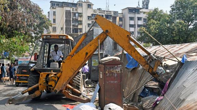 A BMC worker demolishes a part of a property at Pali Naka in Mumbai on Friday. (Hindustan Times) A BMC worker demolishes a part of a property at Pali Naka in Mumbai on Friday. (Hindustan Times)