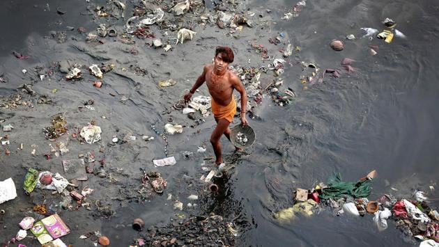 A man sifts through rubbish in the Yamuna River in New Delhi. (Cathal McNaughton / REUTERS)