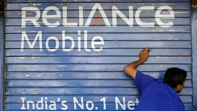 A man opens the shutter of a shop painted with an advertisement of Reliance Communications in Mumbai, India, November 3, 2015. (Reuters File Photo) A man opens the shutter of a shop painted with an advertisement of Reliance Communications in Mumbai, India, November 3, 2015. (Reuters File Photo)
