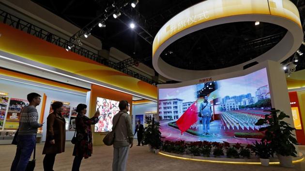 In this file photo, visitors watch a man appearing on a screen as he experiences a national anthem flag raising ceremony at an exhibition highlighting China's achievements at the Beijing Exhibition Hall. On Nov 4, 2017, China's rubber-stamp legislature made disrespecting the national anthem a criminal offense punishable by up to three years in prison. (AP Photo) In this file photo, visitors watch a man appearing on a screen as he experiences a national anthem flag raising ceremony at an exhibition highlighting China's achievements at the Beijing Exhibition Hall. On Nov 4, 2017, China's rubber-stamp legislature made disrespecting the national anthem a criminal offense punishable by up to three years in prison. (AP Photo)