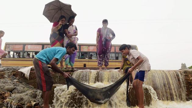 People try to catch fish after a compound wall collapsed near Red Hills in Chennai on Thursday. The Met department said rain or thundershowers were likely to occur at many places over coastal Tamil Nadu and Puducherry and at a few places in the interior. Heavy rain at isolated places was very likely. (R Senthil Kumar / PTI) People try to catch fish after a compound wall collapsed near Red Hills in Chennai on Thursday. The Met department said rain or thundershowers were likely to occur at many places over coastal Tamil Nadu and Puducherry and at a few places in the interior. Heavy rain at isolated places was very likely. (R Senthil Kumar / PTI)