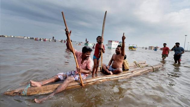People use wooden planks as a raft to wade through floodwaters near the Marina beach shore following heavy rain in Chennai on Friday. The Tamil Nadu capital saw traffic snarls, water logging and flooding in low-lying areas as heavy showers continues to lash various parts of the city and coastal areas of the southern state. (PTI) People use wooden planks as a raft to wade through floodwaters near the Marina beach shore following heavy rain in Chennai on Friday. The Tamil Nadu capital saw traffic snarls, water logging and flooding in low-lying areas as heavy showers continues to lash various parts of the city and coastal areas of the southern state. (PTI)