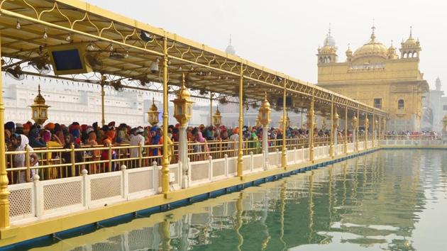 Devotees stand in line at the Golden Temple in Amritsar, awaiting to enter the sanctum sanctorum to pay obeisance on the occasion of Gurpurab. (Sameer Sehgal /HT)