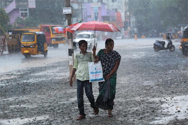 A woman and a boy walk under an umbrella during heavy rains in Nagercoil, Tamil Nadu on Saturday. (PTI Photo) A woman and a boy walk under an umbrella during heavy rains in Nagercoil, Tamil Nadu on Saturday. (PTI Photo)