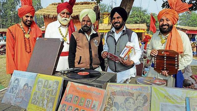 Bheem Lubaneawala (in yellow turban) of Nabha along with his 90-year-old gramophone and old music records at the Chandigarh National Crafts Mela at Kalagram.(Keshav Singh/HT)