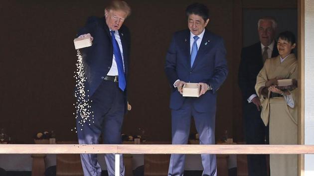 US President Donald Trump pours out the remaining fish food from a container as he feeds carp at a koi pond with Japan's Prime Minister Shinzo Abe in Tokyo, Japan. (AP Photo) US President Donald Trump pours out the remaining fish food from a container as he feeds carp at a koi pond with Japan's Prime Minister Shinzo Abe in Tokyo, Japan. (AP Photo)