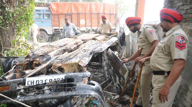 Police officials looking at the burnt car at Chahru police station opposite Lovely Professional University near Jalandhar on Monday. (Pardeep Pandit/HT) Police officials looking at the burnt car at Chahru police station opposite Lovely Professional University near Jalandhar on Monday. (Pardeep Pandit/HT)