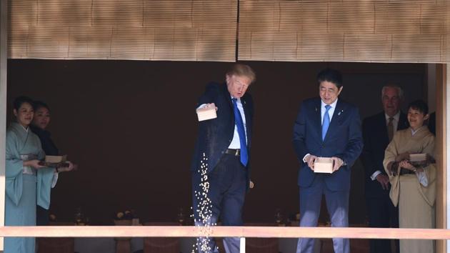 US President Donald Trump (C) feeds koi fish as Japanese Prime Minister Shinzo Abe (R) looks on during a welcoming ceremony in Tokyo on Monday. (AFP) US President Donald Trump (C) feeds koi fish as Japanese Prime Minister Shinzo Abe (R) looks on during a welcoming ceremony in Tokyo on Monday. (AFP)