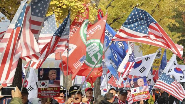 South Koreans hold banners with pictures of US President Donald Trump and wave flags during a rally welcoming his visit to the country in downtown Seoul, South Korea, on Friday. (AP file) South Koreans hold banners with pictures of US President Donald Trump and wave flags during a rally welcoming his visit to the country in downtown Seoul, South Korea, on Friday. (AP file)