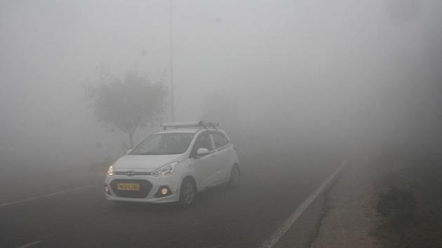 Vehicles passing through dense fog on the Rohtak-Delhi road (NH-10) in Rohtak. (Ht Photo)