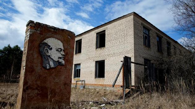 A panel with a portrait of Vladimir Lenin and an abandoned building are seen at the 30km exclusion zone around the Chernobyl nuclear reactor in the abandoned village of Orevichi, Belarus. When he died in 1924, Soviet authorities displayed his embalmed body in a mausoleum in Moscow’s Red Square where it lies to this day. (Vasily Fedosenko / REUTERS)