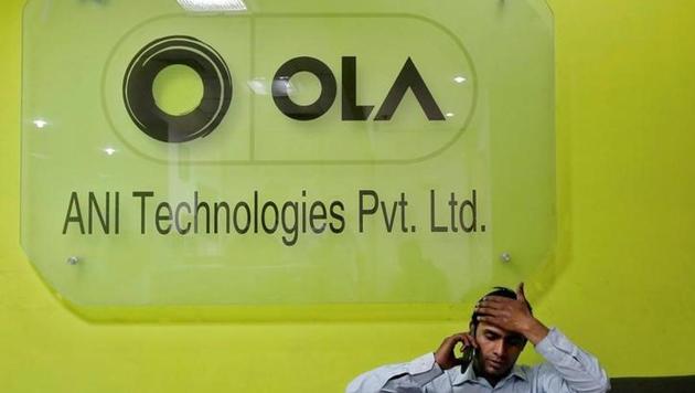 An employee speaks over his phone as he sits at the front desk inside the office of Ola cab service in Gurgaon.(Reuters)